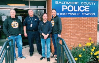 People posing for image infront of Baltimore County Police station