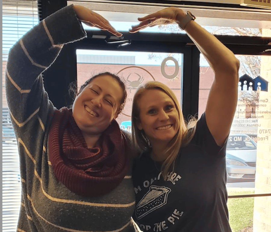 Amy and client making a heart